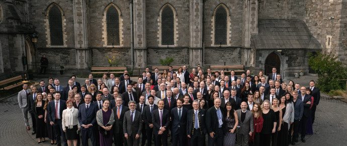 A large group of IMAP member-firm advisers photographed outside a stone church