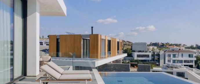 A contemporary hillside villa with an infinity pool overlooking a coastal town