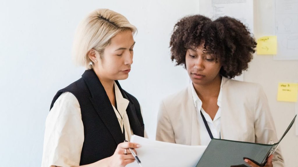 Two colleagues reviewing a document together in an office